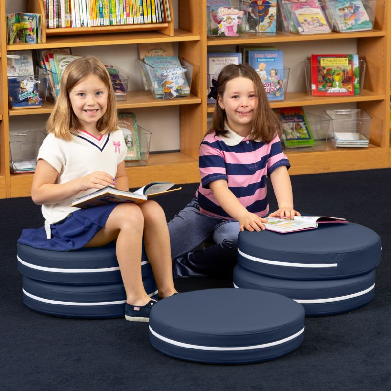 Two children reading in a school library while seated on Jaxx Kirkwood navy blue stacking floor cushions