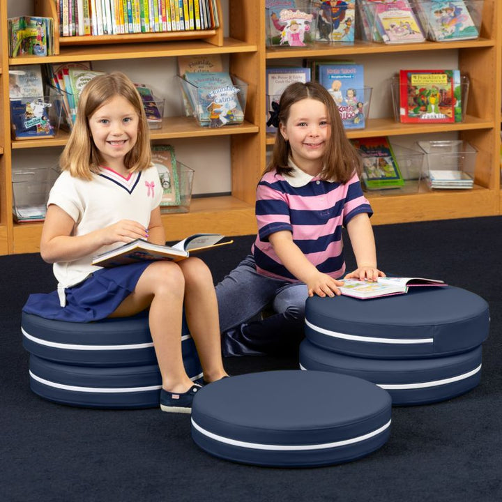 Two children reading in a school library while seated on Jaxx Kirkwood navy blue stacking floor cushions