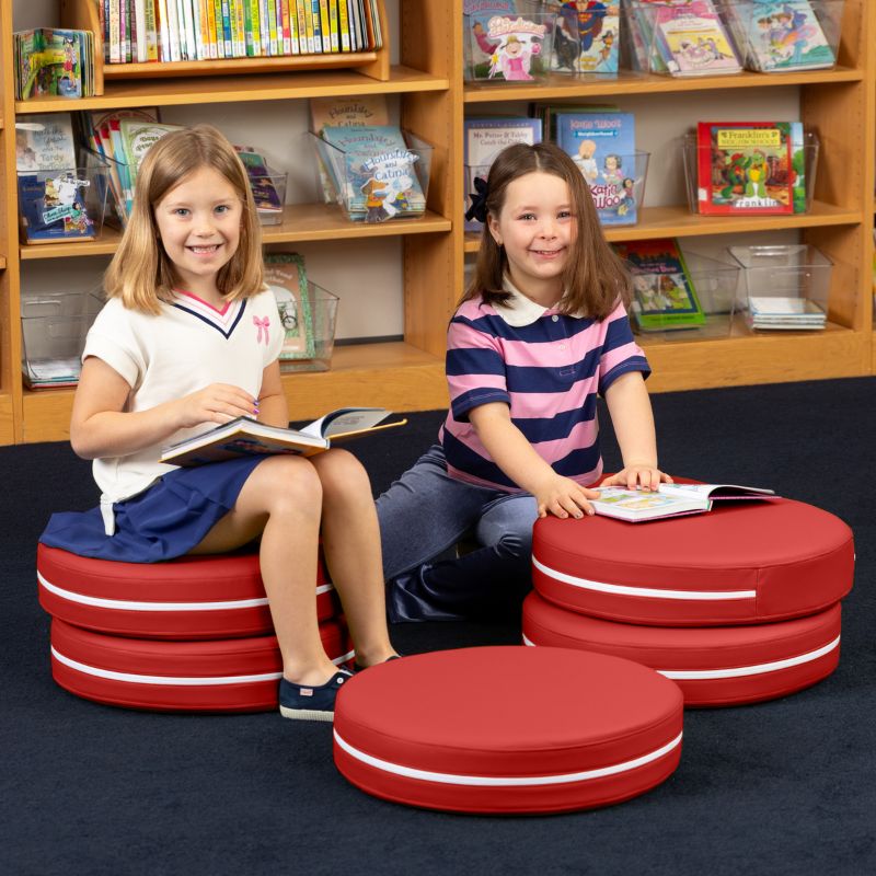 Two children reading in a school library while seated on Jaxx Kirkwood red stacking floor cushions