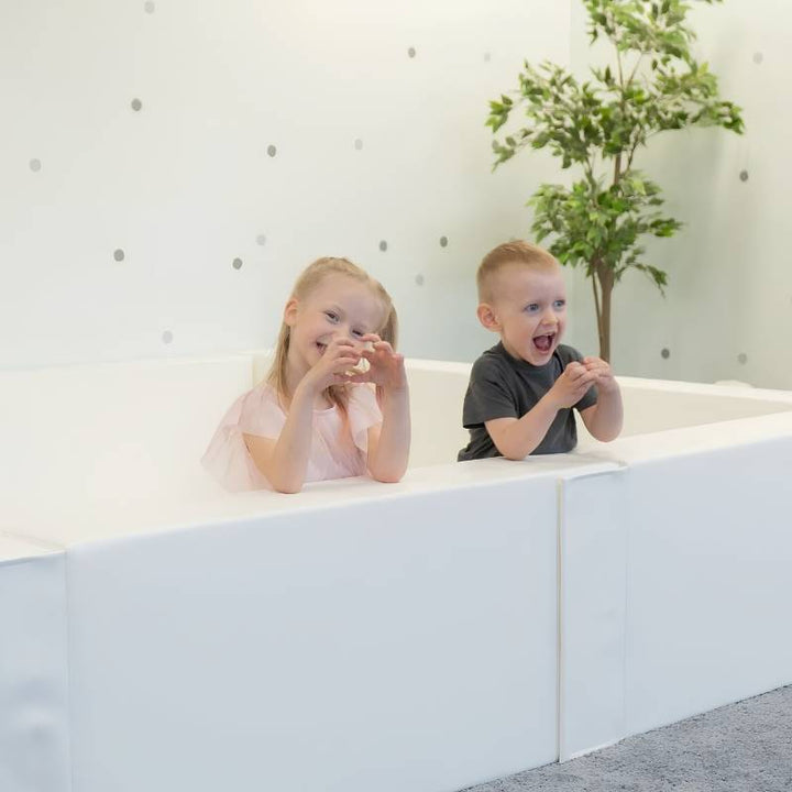 Two children actively playing inside the IGLU Large Square Ball Pit, a commercial ball pit for daycares and therapy rooms