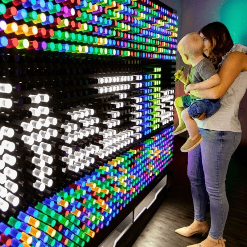 LiteZilla Giant Lite Brite interactive sensory light wall with mom and children placing LitePin