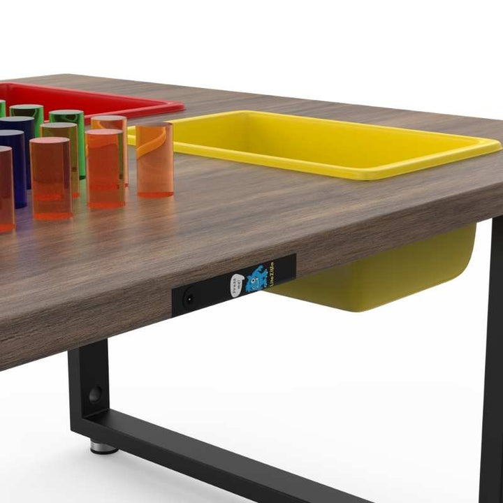 Close-up of the LiteZilla IllumiTable in Walnut Veneer finish showing Mini LitePins, the power button, and storage bins on this sensory light table