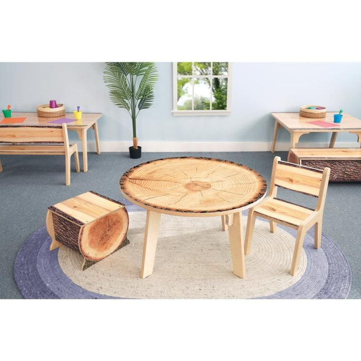 Whitney Brothers Nature View Live Edge Activity Table in round shape with a log stool and Live Edge chair, creating a cozy nature-themed reading space