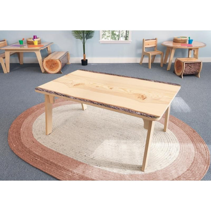 Whitney Brothers Nature View Live Edge Rectangle Table 18H on a round terracotta rug in a nature-themed preschool classroom with log stools and matching chairs