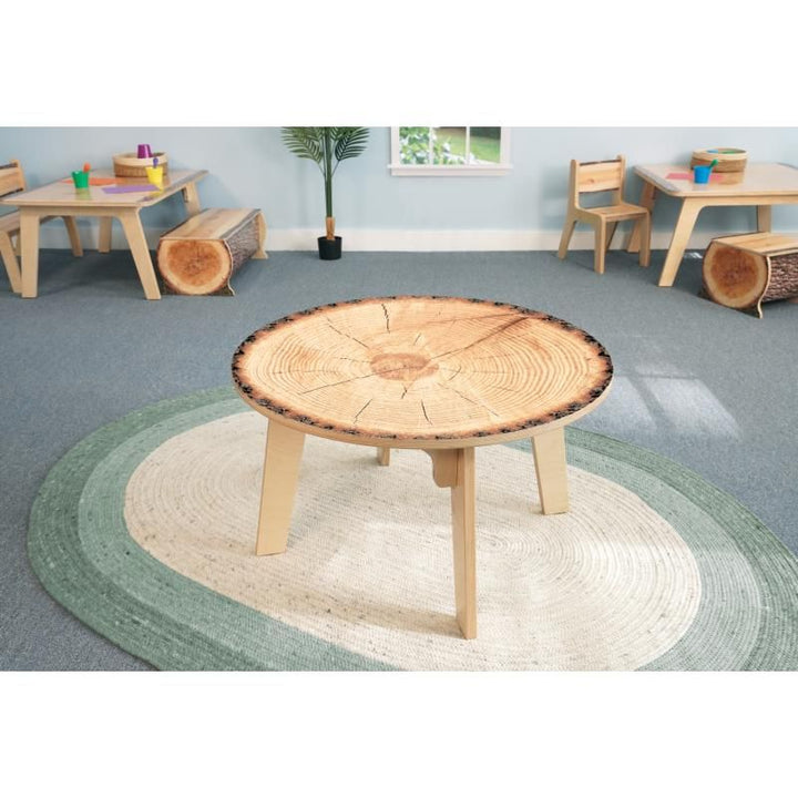 Whitney Brothers Nature View Live Edge Round Table 22H on a sage green woven rug, a nature-inspired kids activity table for daycares and classrooms