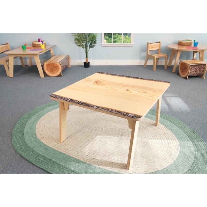 Whitney Brothers Nature View Live Edge Square Table in the 22 inch height on a green woven rug, a live edge activity table for calm classroom spaces