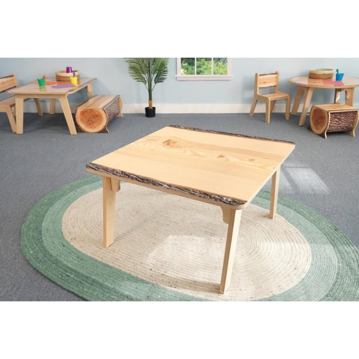 Whitney Brothers Nature View Live Edge Square Table in the 22 inch height on a green woven rug, a live edge activity table for calm classroom spaces