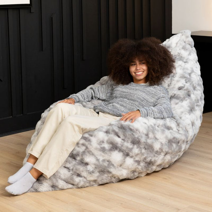 Teen reclining in the Raven-Symoné LoungePuff micro-cushion faux fur lounger in Phantom Grey