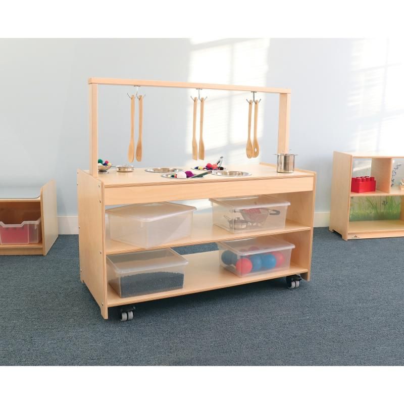 Whitney Brothers Mobile Sensory Play Kitchen in a classroom, with wooden utensils on the maple rack hooks and lockable casters on this mobile sensory table