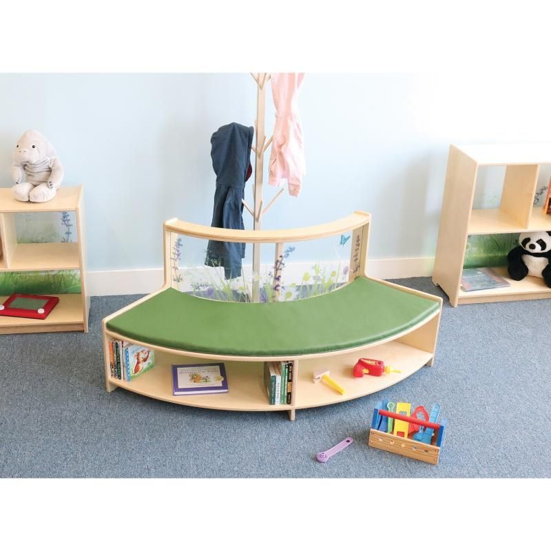 Whitney Brothers Nature View Curved Sofa in the curve-out style with a green cushion and open book storage in a classroom reading nook