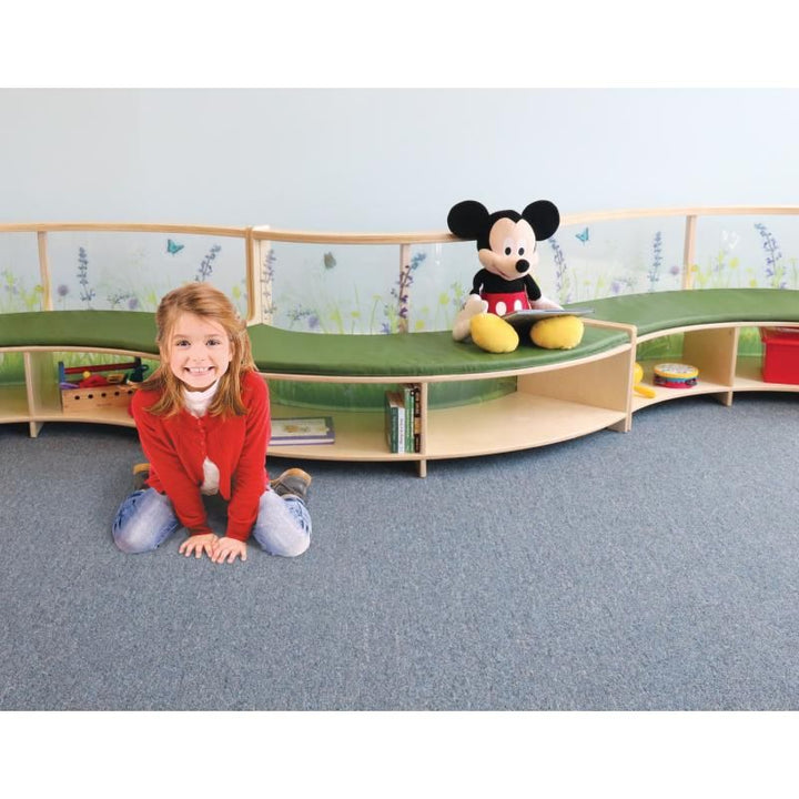 Child kneeling beside Whitney Brothers Nature View Curved Sofas joined in an S-shape to create a flexible kids reading area