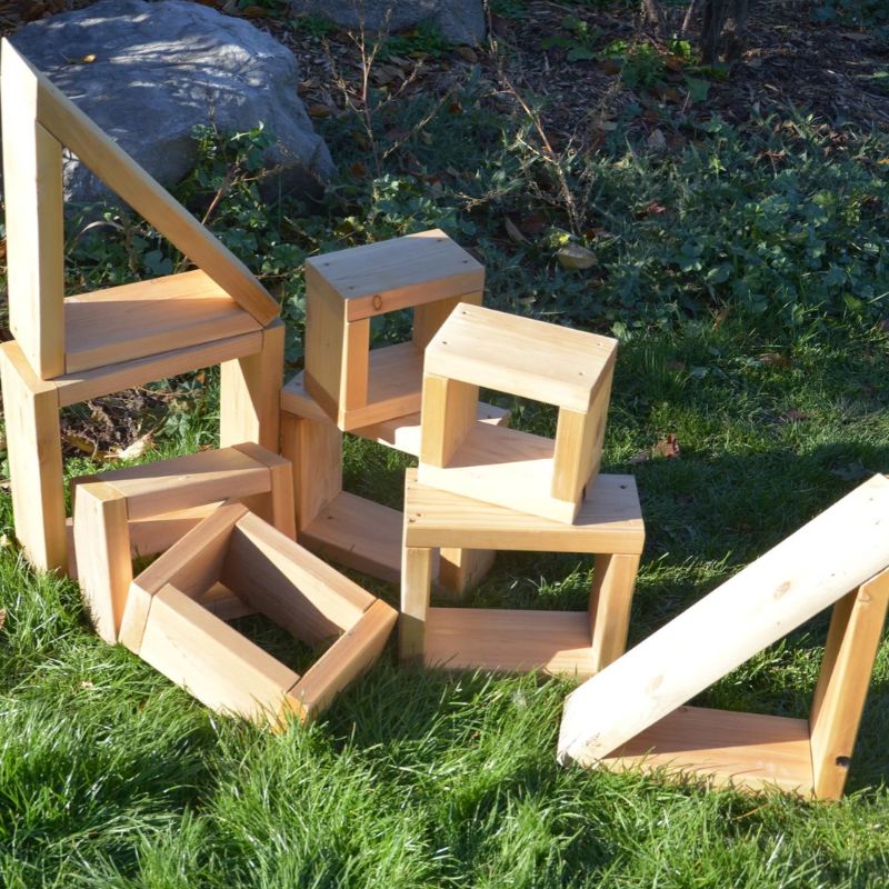 ONP 9 Blocks Western Red Cedar frames stacked on grass outdoors, showing open squares, rectangles and triangles balanced into a freestanding structure