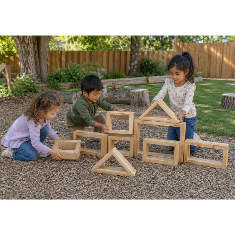 Three children stacking and arranging the ONP 9 Blocks set outdoors, building triangle and square wooden frames into a structure