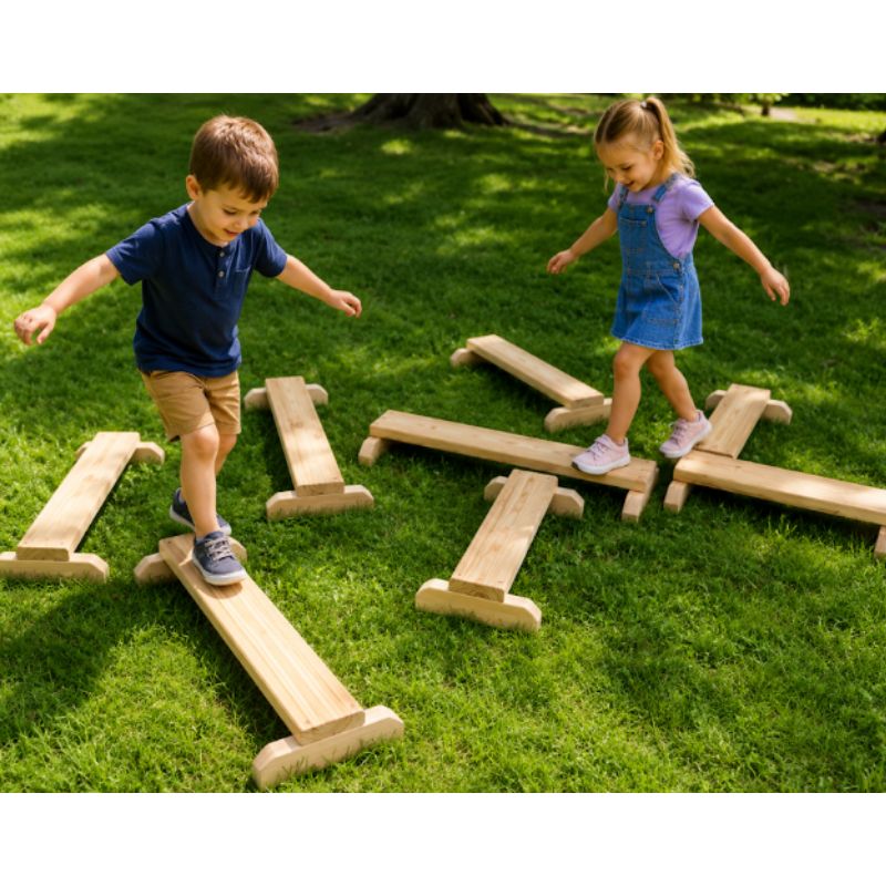 Two children balancing across the ONP Gross Motor Boards outdoors, walking on crossed wooden balance boards on the grass