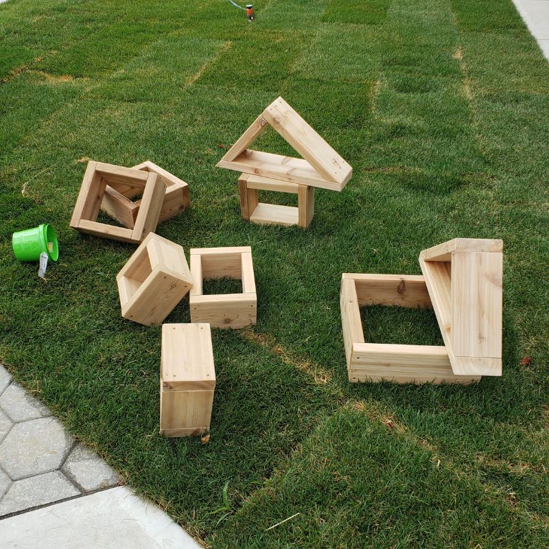 ONP 9-piece outdoor cedar block set photographed from above, showing all Western Red Cedar squares, rectangles, and triangles arranged for early years outdoor play