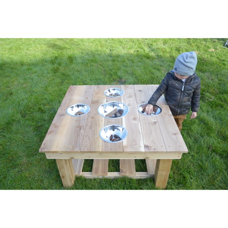 Child playing at the ONP Outdoor Messy Activity Table infant size, exploring the five stainless steel bowls and cedar sensory play station outdoors