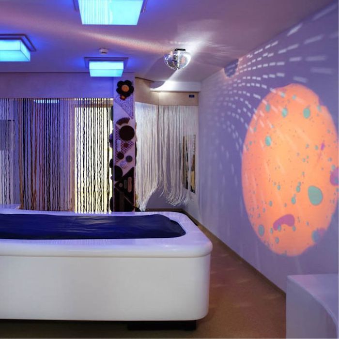 OPTIKinetics Solar 250 LED projector in a bedroom sensory environment, showing how the effects projector transforms a home space into a calming multi-sensory oasis