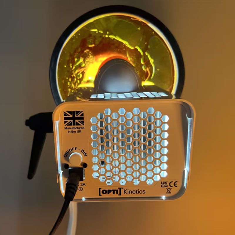Rear panel of the OPTIKinetics Solar 80 sensory projector showing the on/off dim dial and a lit effect wheel projecting warm swirling colour for sensory rooms