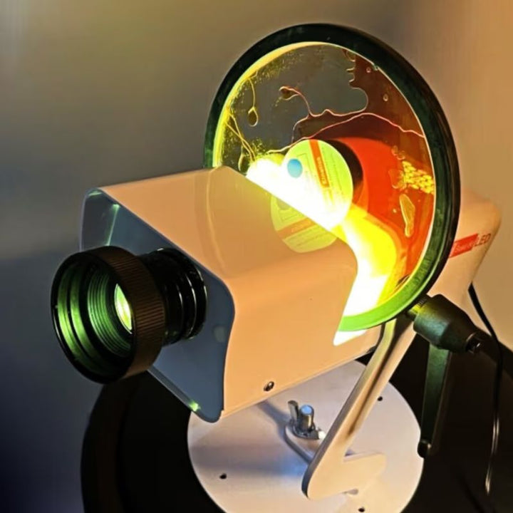 Close view of the OPTIKinetics Solar 80 sensory projector's lens and lit effect wheel, showing the sharp compact optics used for visual sensory stimulation