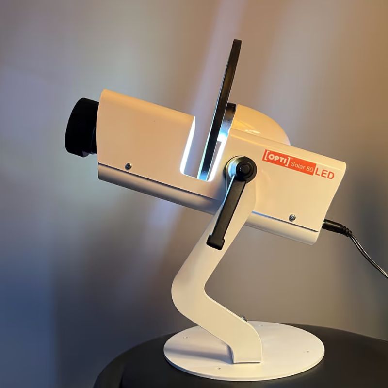 OPTIKinetics Solar 80 sensory projector powered on and casting light from its lens, a compact wifi controlled projector for North American sensory rooms