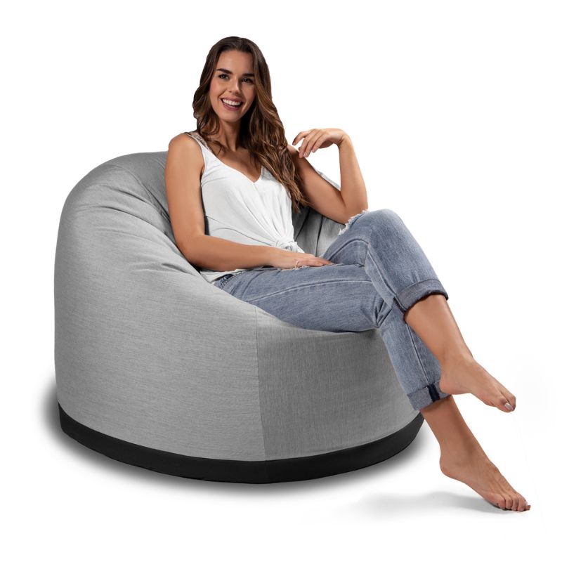 Woman relaxing in the Jaxx Palmetto outdoor bean bag chair in Granite Sunbrella fabric