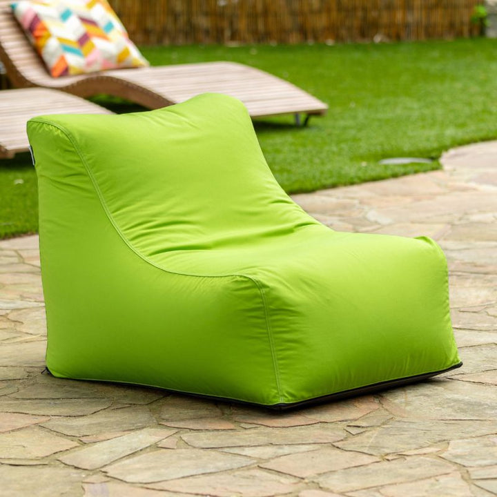 Jaxx Ponce Outdoor Bean Bag Chair in Lime on a backyard flagstone patio, a vivid green weather-resistant bean bag