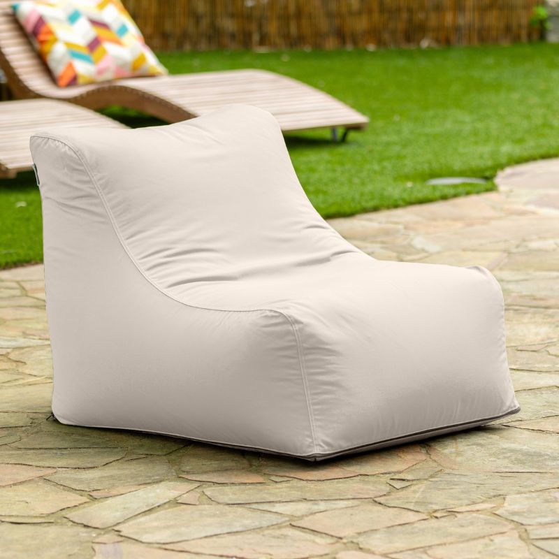 Jaxx Ponce Outdoor Bean Bag Chair in Pearl on a flagstone patio, a soft off-white poolside bean bag with a washable cover