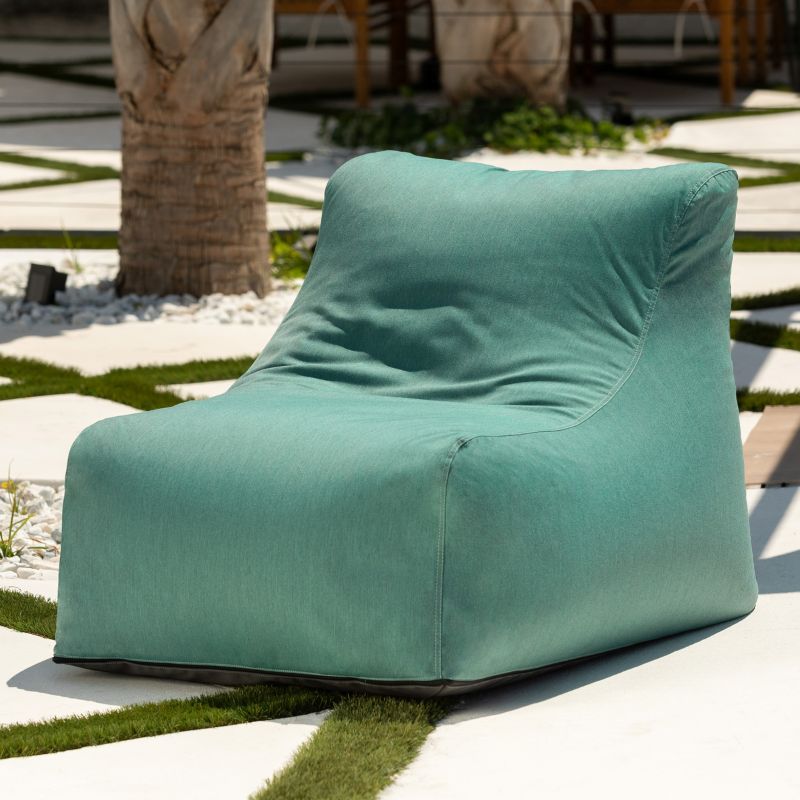 Jaxx Ponce Outdoor Bean Bag Chair in Sunbrella Breeze in a sunny palm courtyard, a seafoam Sunbrella bean bag chair