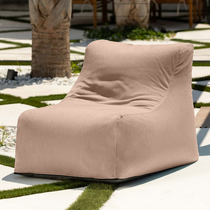 Jaxx Ponce Outdoor Bean Bag Chair in Sunbrella Petal in a palm courtyard, a blush-toned Sunbrella bean bag for outdoor calm corners