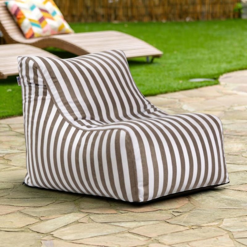 Jaxx Ponce Outdoor Bean Bag Chair in Taupe Stripes on a flagstone patio beside a lounger, a neutral striped poolside bean bag