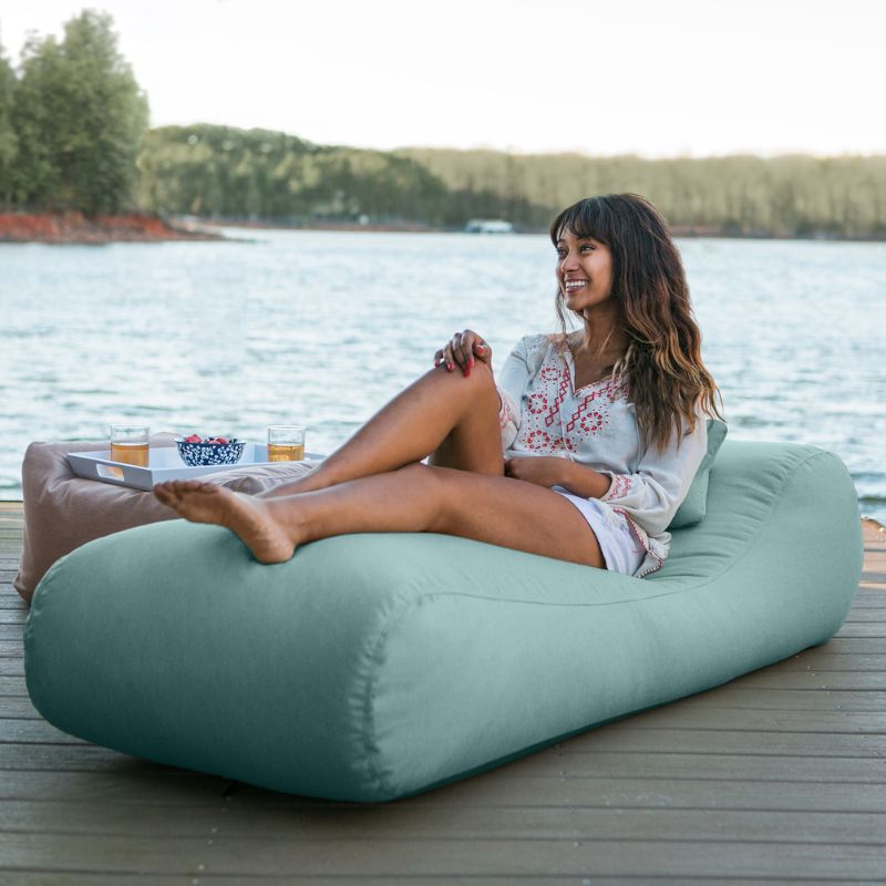 Jaxx Arlo outdoor bean bag lounger in Breeze Sunbrella fabric styled on a backyard lawn