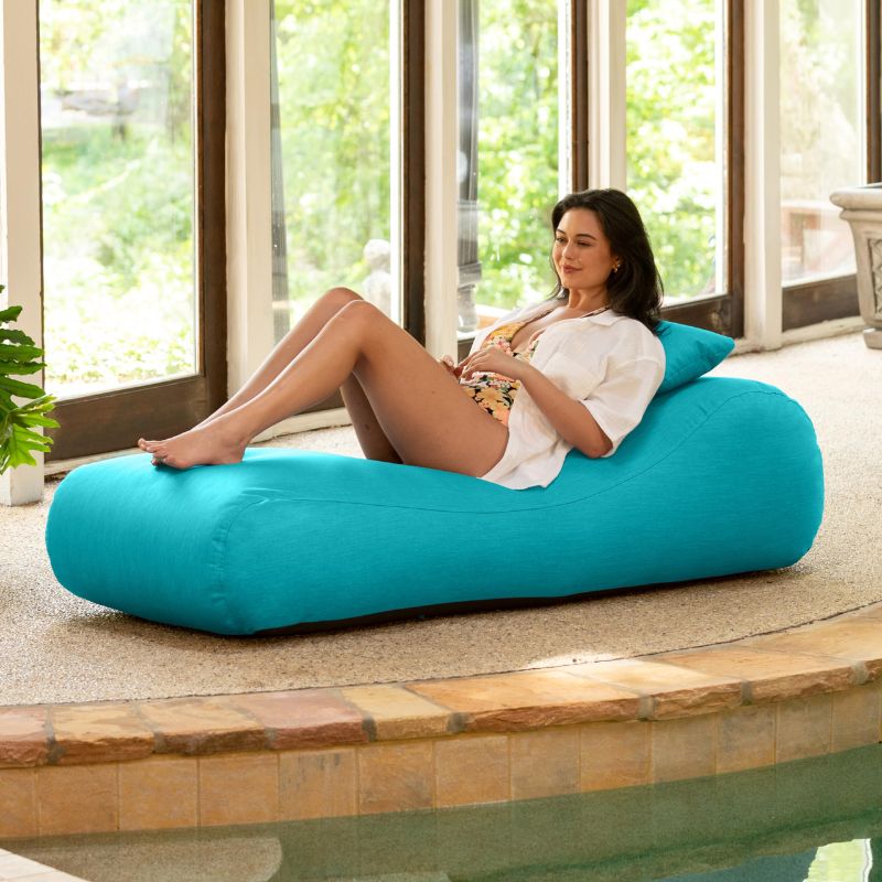 Jaxx Arlo outdoor bean bag lounger in Cancun Blue Sunbrella fabric styled on a backyard lawn for calming outdoor comfort