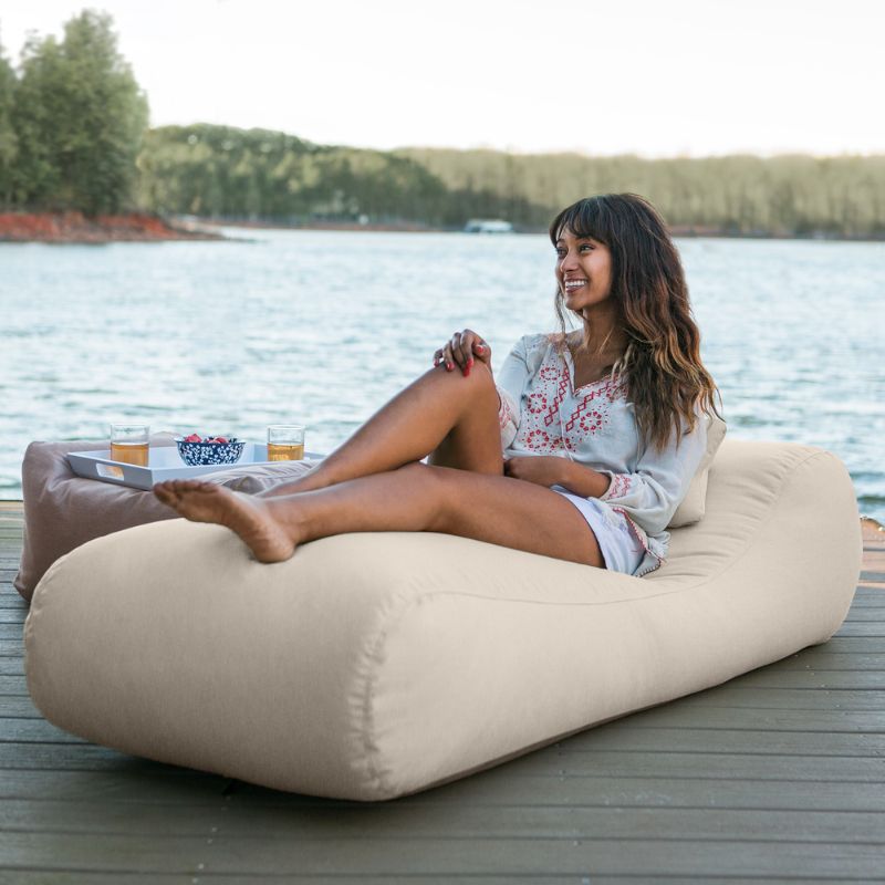 Jaxx Arlo outdoor bean bag lounger in Flax Sunbrella fabric styled on a backyard lawn