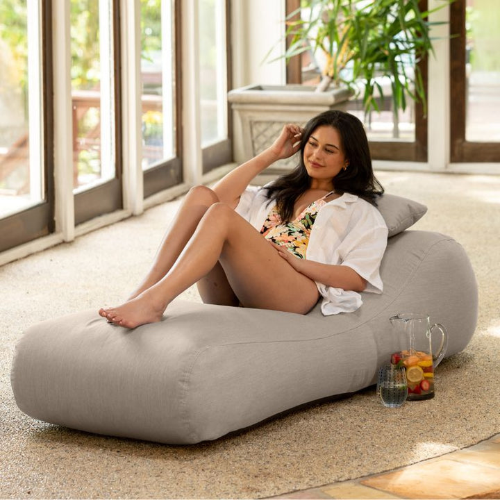 Jaxx Arlo outdoor bean bag lounger in Flax Sunbrella fabric styled in a sunroom for neutral indoor-outdoor comfort