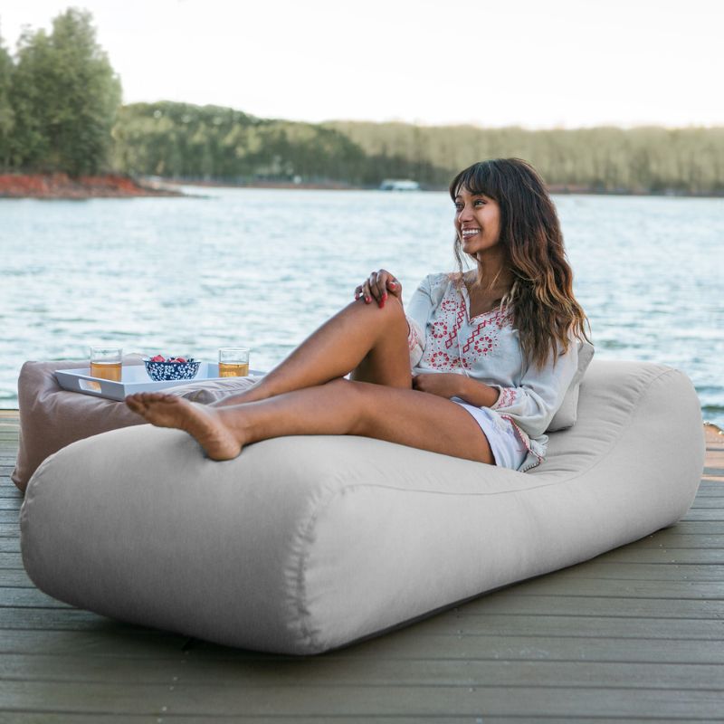 Jaxx Arlo outdoor bean bag lounger in Granite Sunbrella fabric styled on a backyard lawn