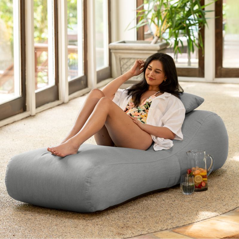 Jaxx Arlo outdoor bean bag lounger in Granite Sunbrella fabric styled in a sunroom for versatile indoor-outdoor comfort