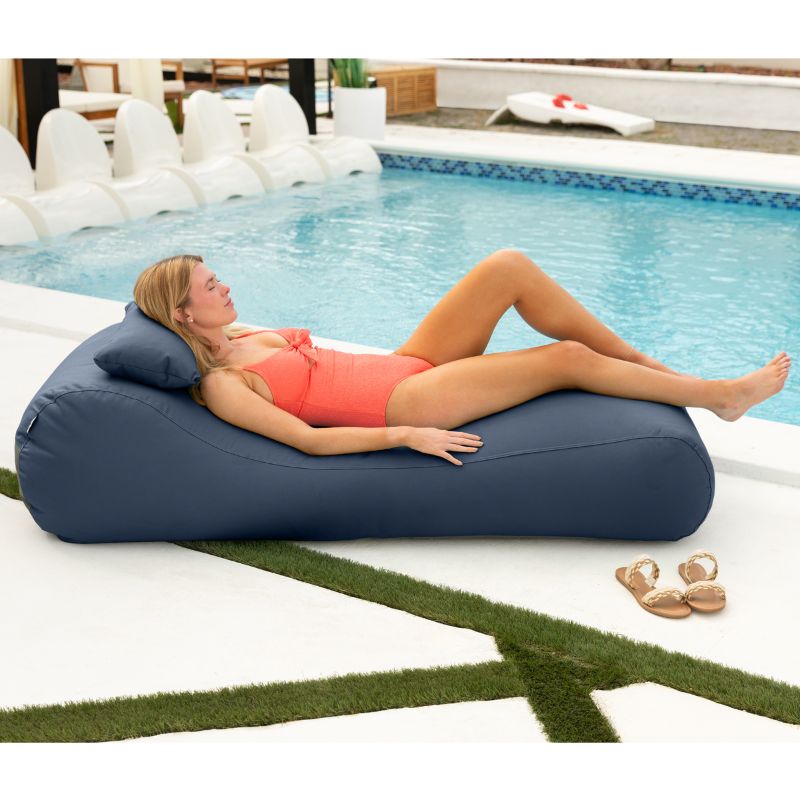 Jaxx Arlo outdoor bean bag lounger in Navy Sunbrella fabric styled on a backyard lawn