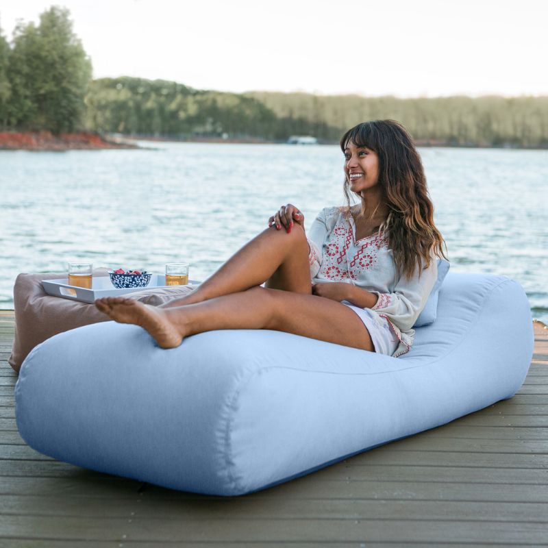 Jaxx Arlo outdoor bean bag lounger in Ocean Sunbrella fabric styled on a backyard lawn