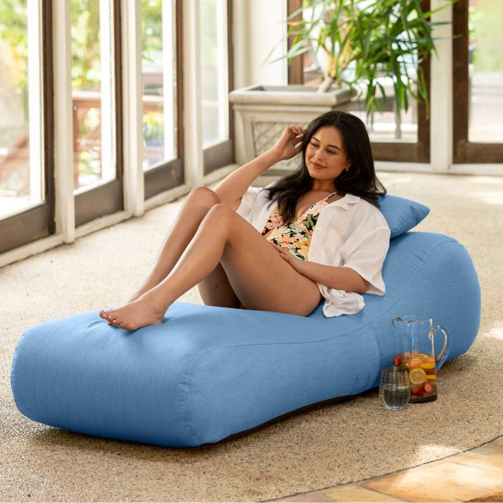 Jaxx Arlo outdoor bean bag lounger in ocean Sunbrella fabric styled in a sunroom for calming indoor-outdoor comfort