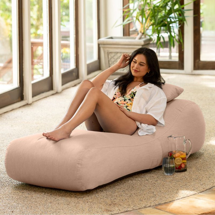 Jaxx Arlo outdoor bean bag lounger in Petal Sunbrella fabric styled in a sunroom for soft indoor-outdoor comfort