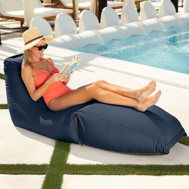 Woman reading poolside on the Jaxx Prado outdoor bean bag lounger in Navy