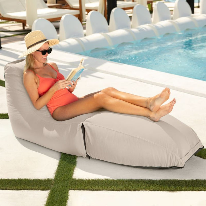 Woman reading poolside on the Prado outdoor bean bag lounger in White