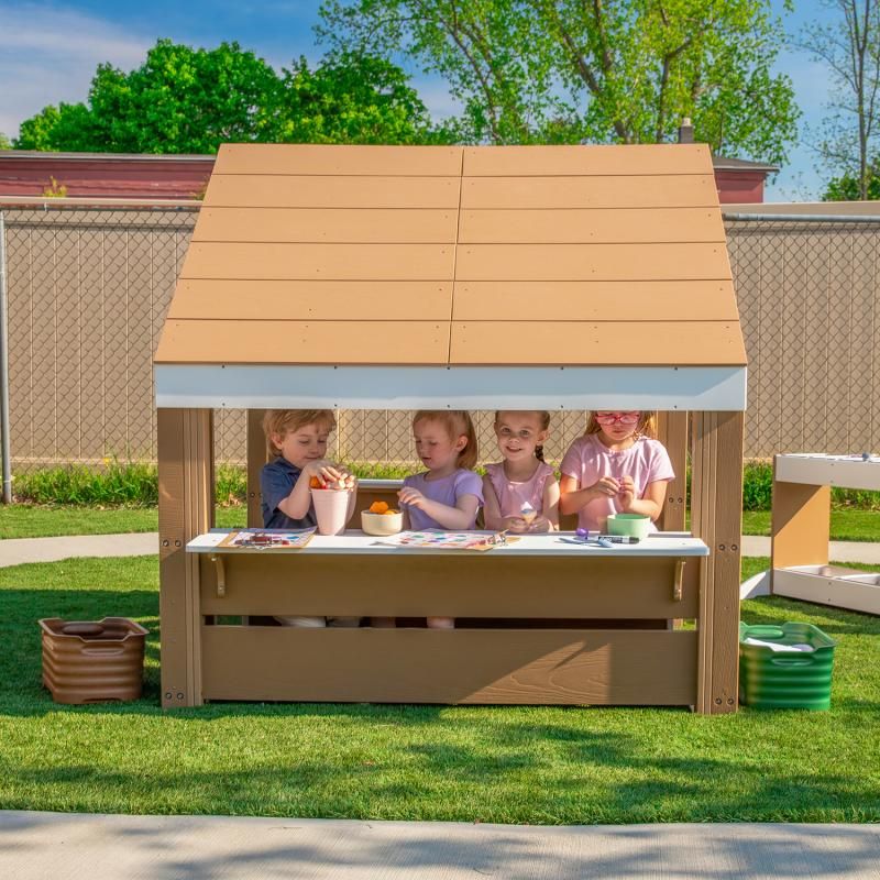 Four preschoolers sharing an art activity at the Whitney Brothers outdoorED Learning Pavilion, a spacious outdoor classroom pavilion built for small-group learning