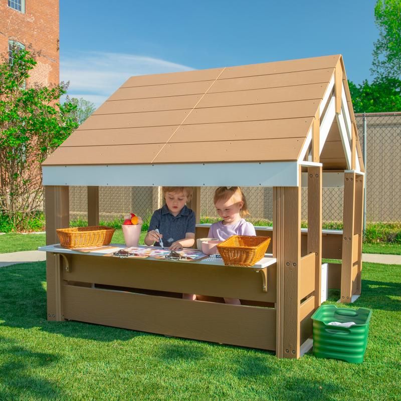 Two young children drawing side by side under the shaded roof of the Whitney Brothers outdoorED Learning Pavilion, a preschool outdoor learning shelter