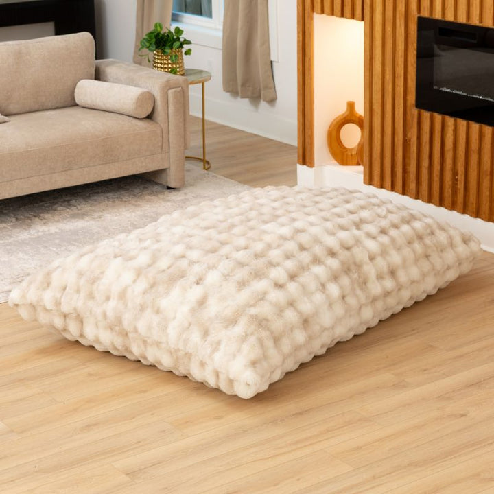 The oversized Raven-Symoné LoungePuff faux fur floor lounger laid flat in Phantom Cream