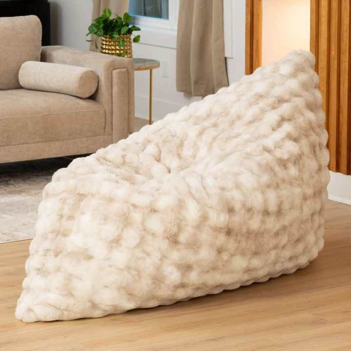 The oversized Raven-Symoné LoungePuff faux fur lounger propped upright in Phantom Cream