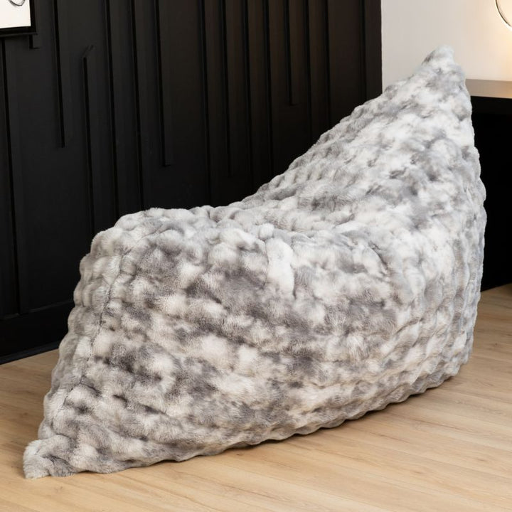 The oversized Raven-Symoné LoungePuff faux fur lounger propped upright in Phantom Grey
