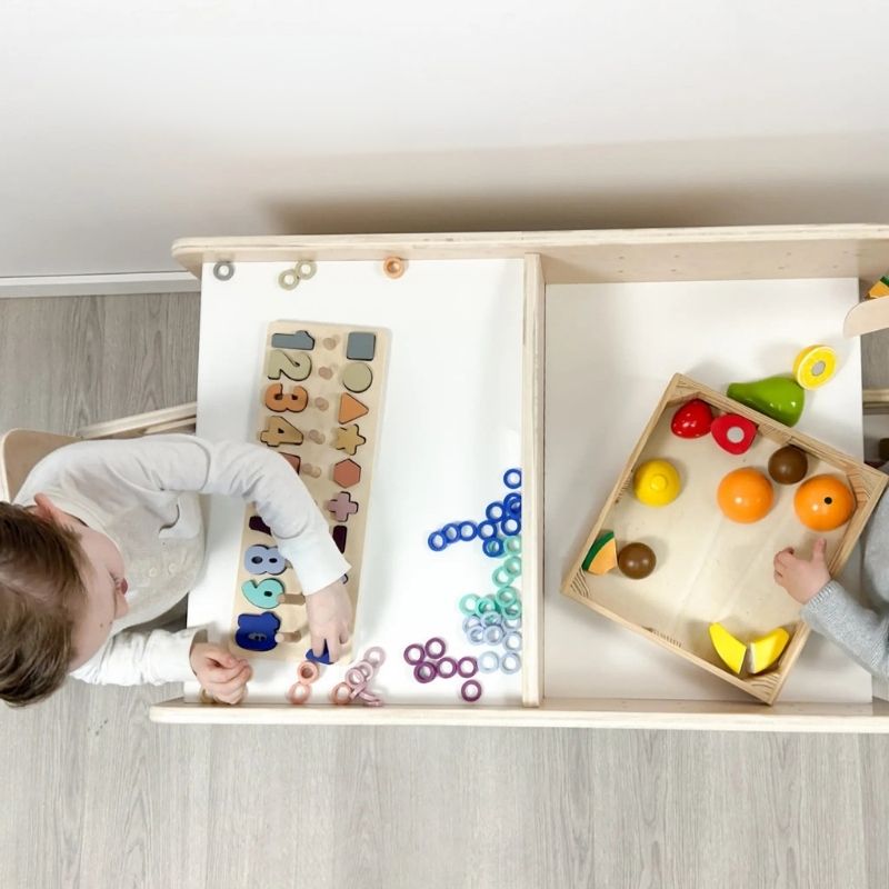 Top-down view of two children actively using the Sapiens Child Papaya Double Montessori Table and Chair Set, showing both children engaged simultaneously at the adjustable child-height workspace