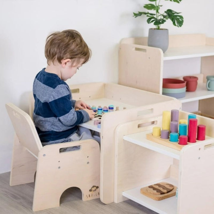 Boy child actively engaged at the Sapiens Child Papaya Set Montessori weaning table in a landscape view, demonstrating the adjustable child-height table supporting independent learning and play