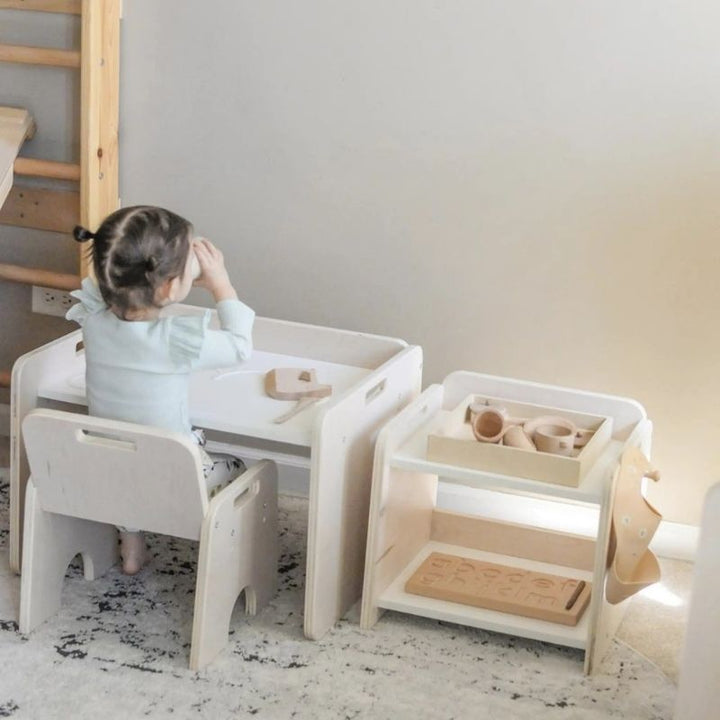 Child actively playing at the Sapiens Child Papaya Set Montessori weaning table in a landscape view, showing the adjustable child-height table and chair supporting independent activity made in Vancouver Canada